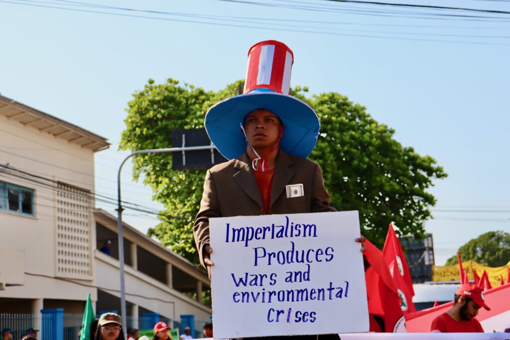 Manifestação na Marcha Global pela Justiça Climática, durante a COP 30. Em protesto, manifestante afirma: “O imperialismo produz guerras e crises ambientais”
Créditos: Cláudia Pereira