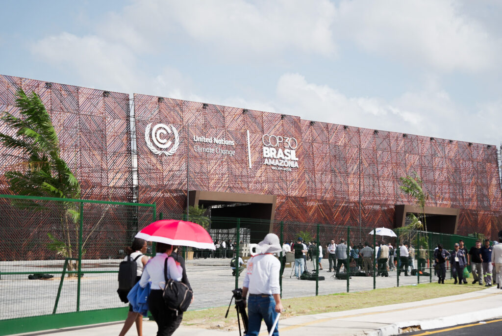 Debaixo de Belém sob sol forte e calor extremo, delegações chegam a Blue Zone no primeiro dia da COP 30 em Belém. Novembro, 2025. Foto: Rodrigo Correia.